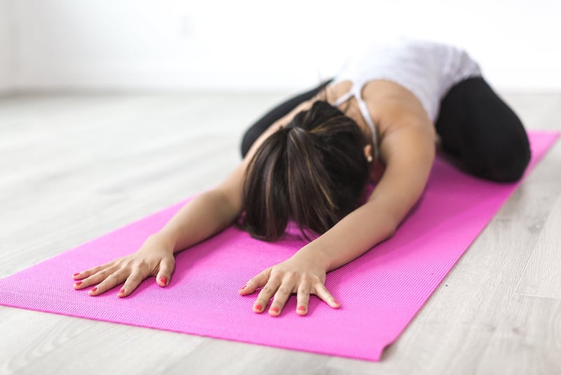Woman practicing yoga at sunset